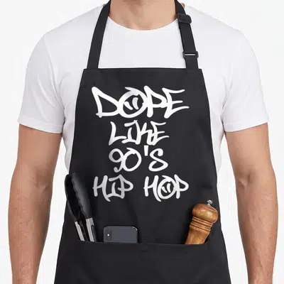 Dope hip aprons - White graffiti style text reading DOPE LIKE 90S HIP HOP stacked vertically — shown on a black cotton canvas apron against a white background
