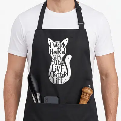 Vintage hard cat apron - White sitting cat silhouette filled with grey text and small stars — shown on a black cotton canvas apron against a white background