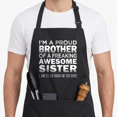 Proud nun apron - White stacked typography reading Proud Brother of Awesome Sister on black background — shown on a black cotton canvas apron against a white background