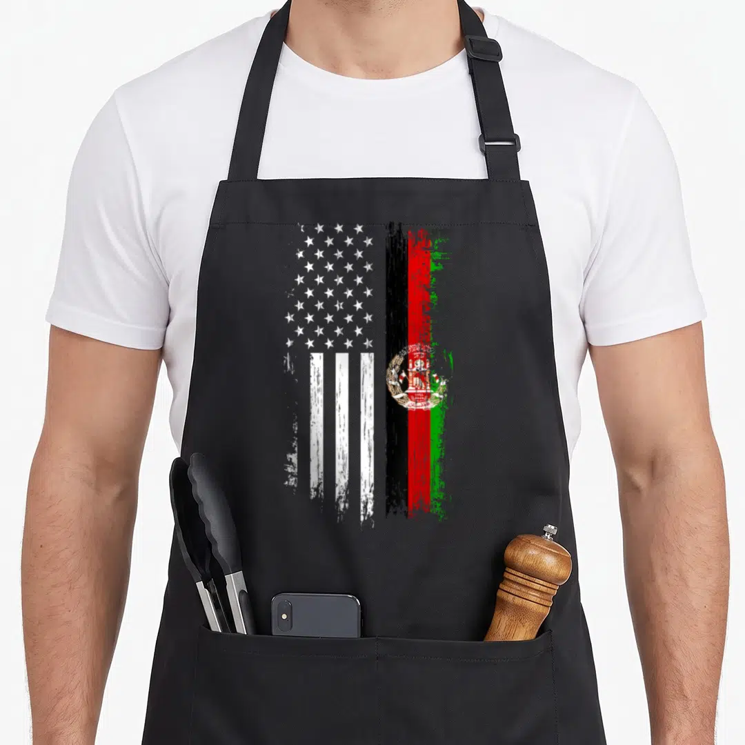 Afghanistan american flag apron - Two distressed flags side-by-side in white, black, red, and green paint strokes — shown on a black cotton canvas apron against a white background