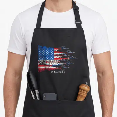 Anniversary flag 4th of july apron - Six jets forming US flag smoke trails with 250 years 1776-2026 text — shown on a black cotton canvas apron against a white background