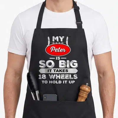Peter truck apron - Red oval Peter sign and stacked white text reading My Peter is So Big It Takes 18 Wheels to Hold it — shown on a black cotton canvas apron against a white background
