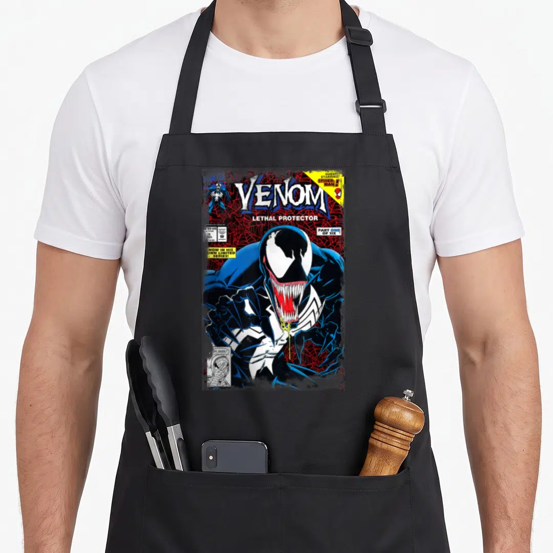 Comic cover apron - Venom comic cover print with Lethal Protector title and Spider-Man guest star box — shown on a black cotton canvas apron against a white background