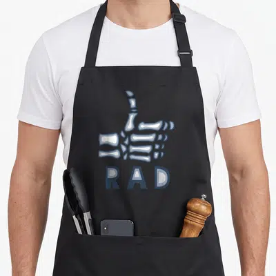 Tech x ray apron - Cartoon skeleton hand thumbs up above RAD text in blue grey and white — shown on a black cotton canvas apron against a white background