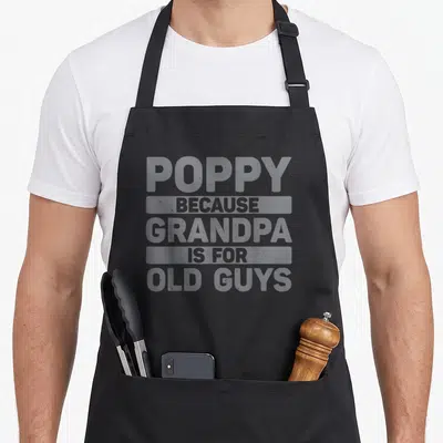 Grandpa grandkid father day apron - Grey stacked text reading Poppy Because Grandpa Is For Old Guys — shown on a black cotton canvas apron against a white background