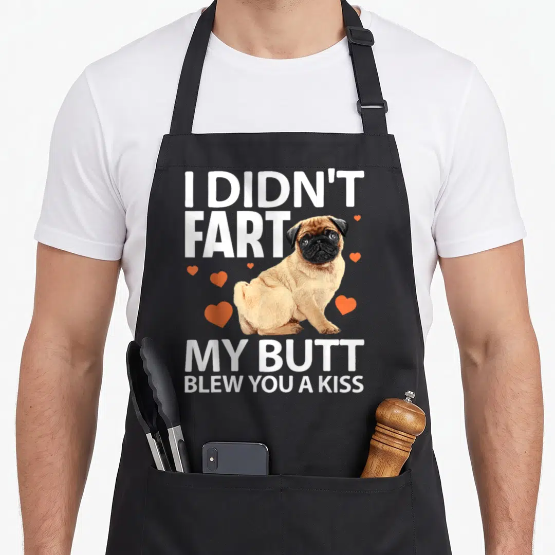 Pug pet top dog aprons - Tan pug photo with white text I didn't fart my butt blew you a kiss and orange hearts — shown on a black cotton canvas apron against a white background
