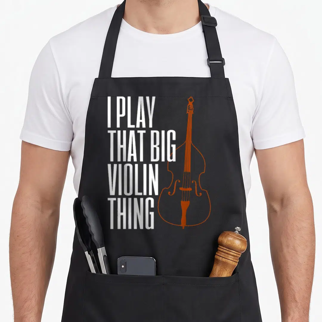 Violin double apron - I PLAY THAT BIG VIOLIN THING text next to orange-brown double bass outline — shown on a black cotton canvas apron against a white background
