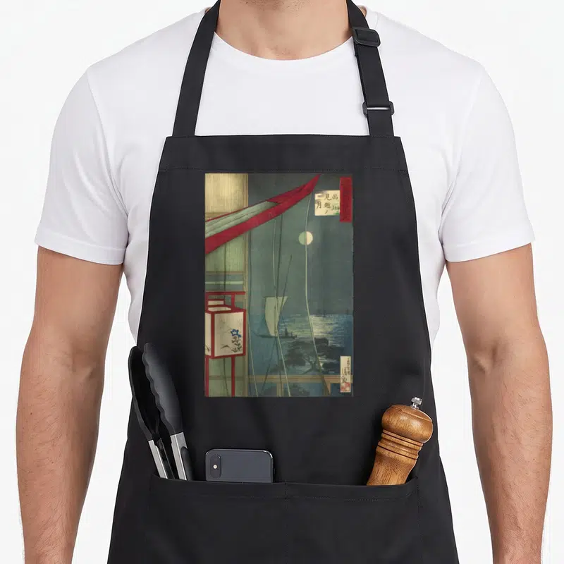 Japanese beyond apron - Moonlit sea with boat, red curtain, white lantern, and Japanese text in dark blue and red — shown on a black cotton canvas apron against a white background