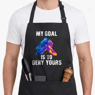 Deny hockey ice apron - Multicolored watercolor goalie between MY GOAL IS TO DENY YOURS text — shown on a black cotton canvas apron against a white background