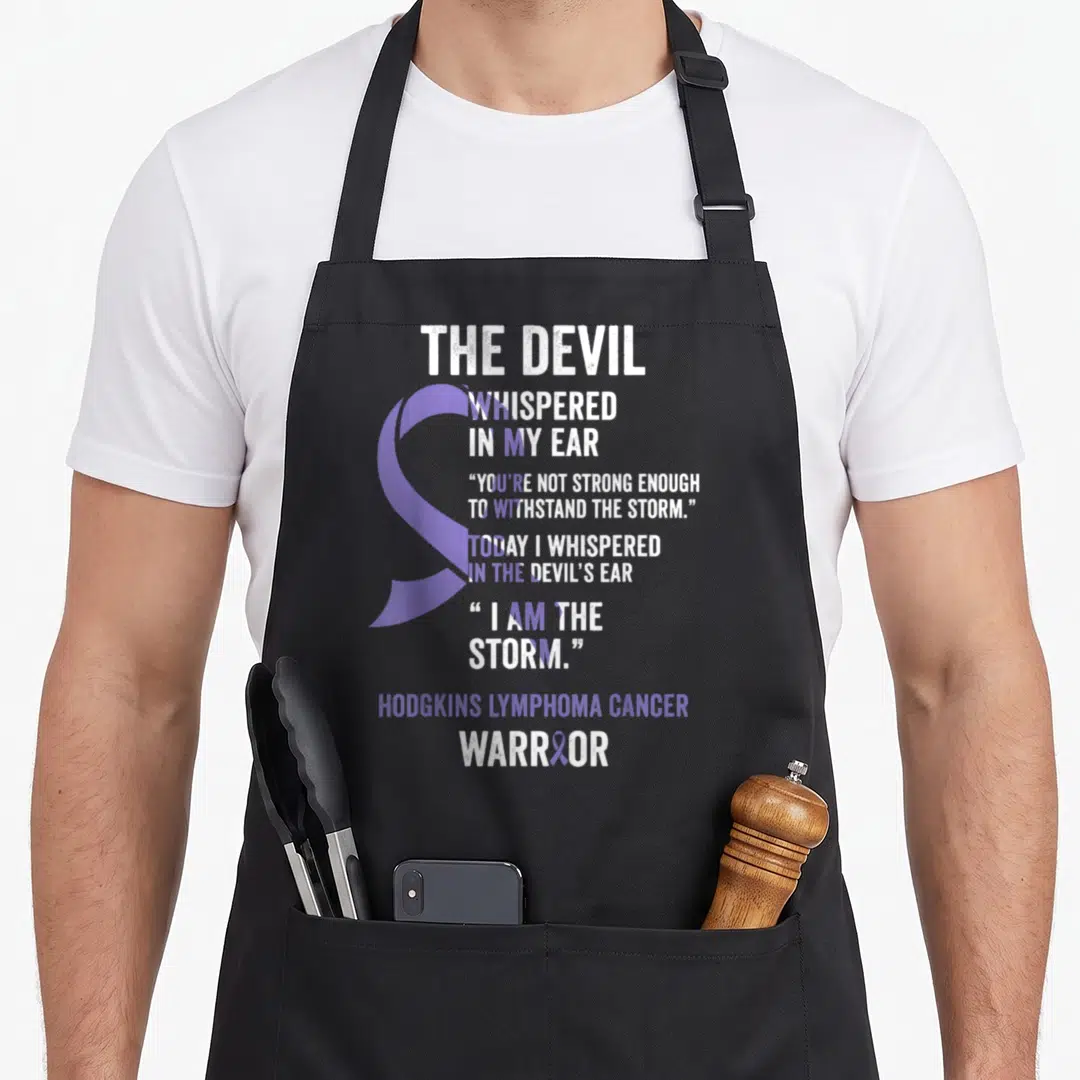 Hodgkin devil's apron - Purple ribbon behind white distressed text reading I AM THE STORM and Hodgkins Lymphoma Cancer — shown on a black cotton canvas apron against a white background