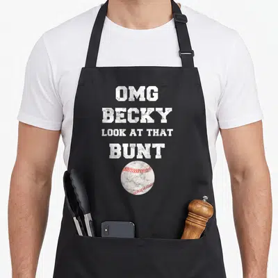 Omg baseball apron - White distressed text reading OMG BECKY LOOK AT THAT BUNT above a baseball with red stitching — shown on a black cotton canvas apron against a white background