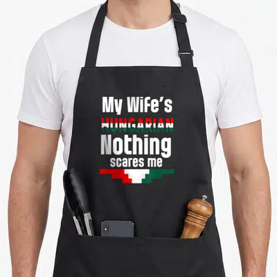 Hungarian husband wife aprons - Text My Wife's HUNGARIAN Nothing scares me with red white and green flag graphic — shown on a black cotton canvas apron against a white background