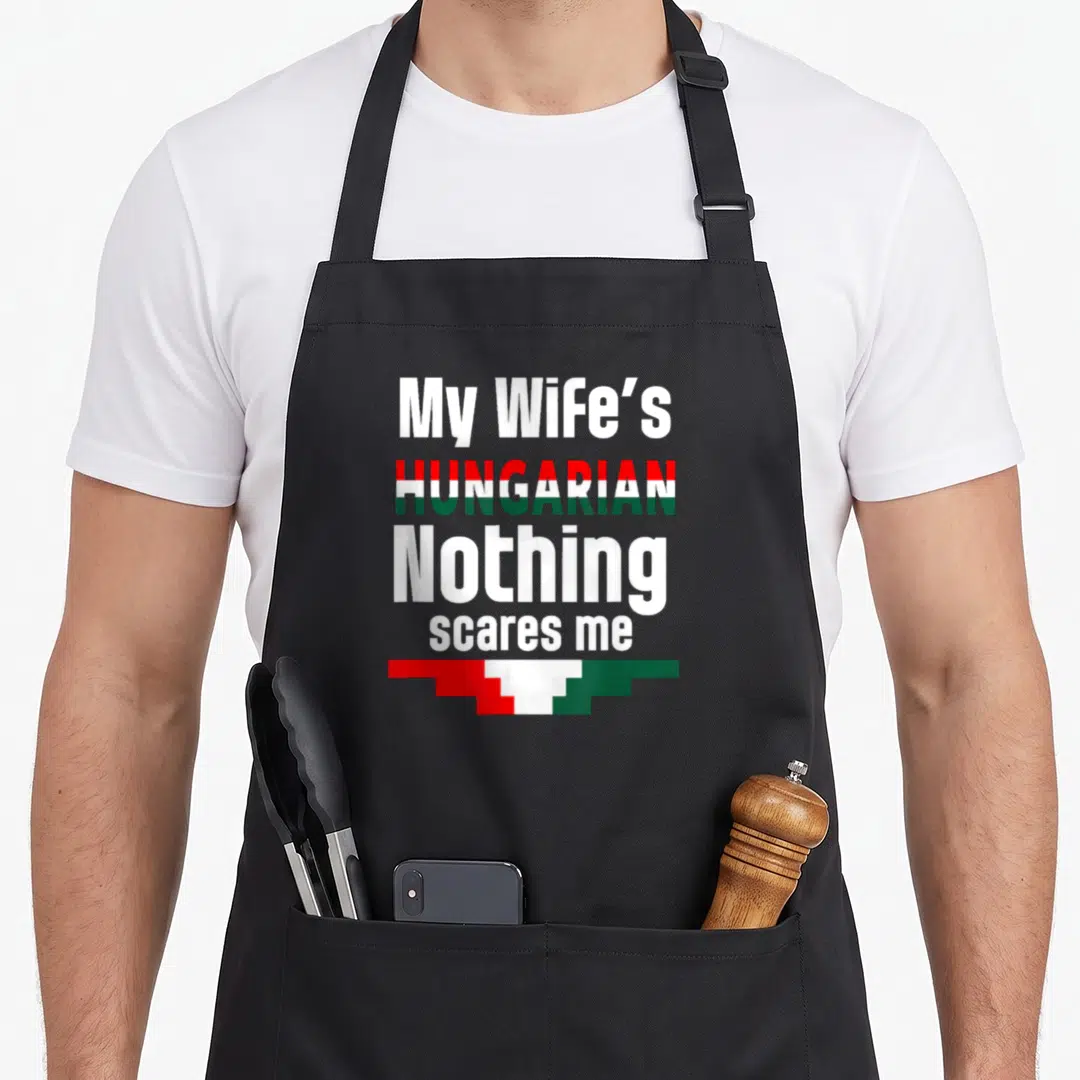 Hungarian husband wife aprons - Text My Wife's HUNGARIAN Nothing scares me with red white and green flag graphic — shown on a black cotton canvas apron against a white background