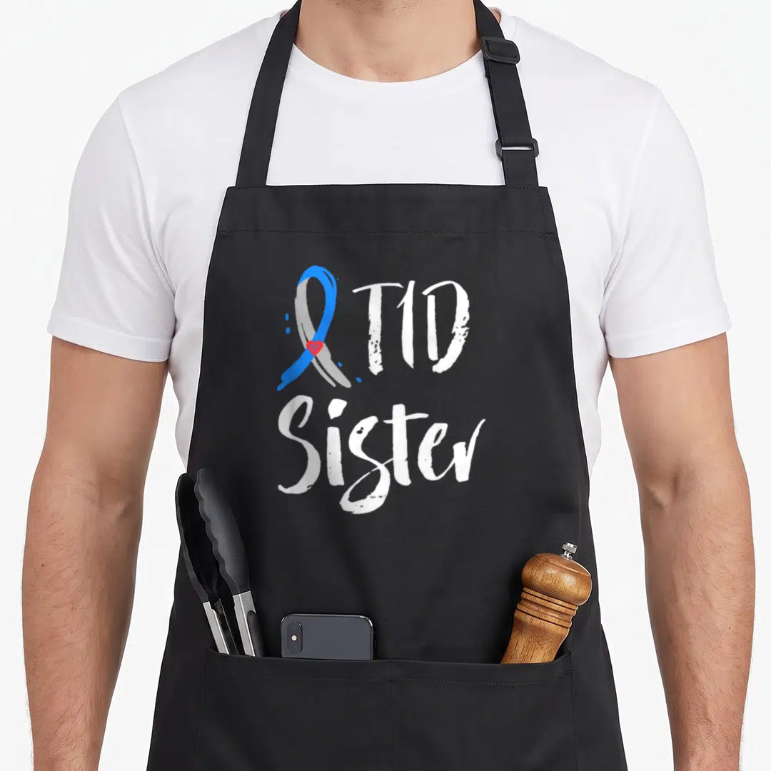Sister diabetes awareness apron - Blue grey ribbon with red heart and white T1D Sister text — shown on a black cotton canvas apron against a white background