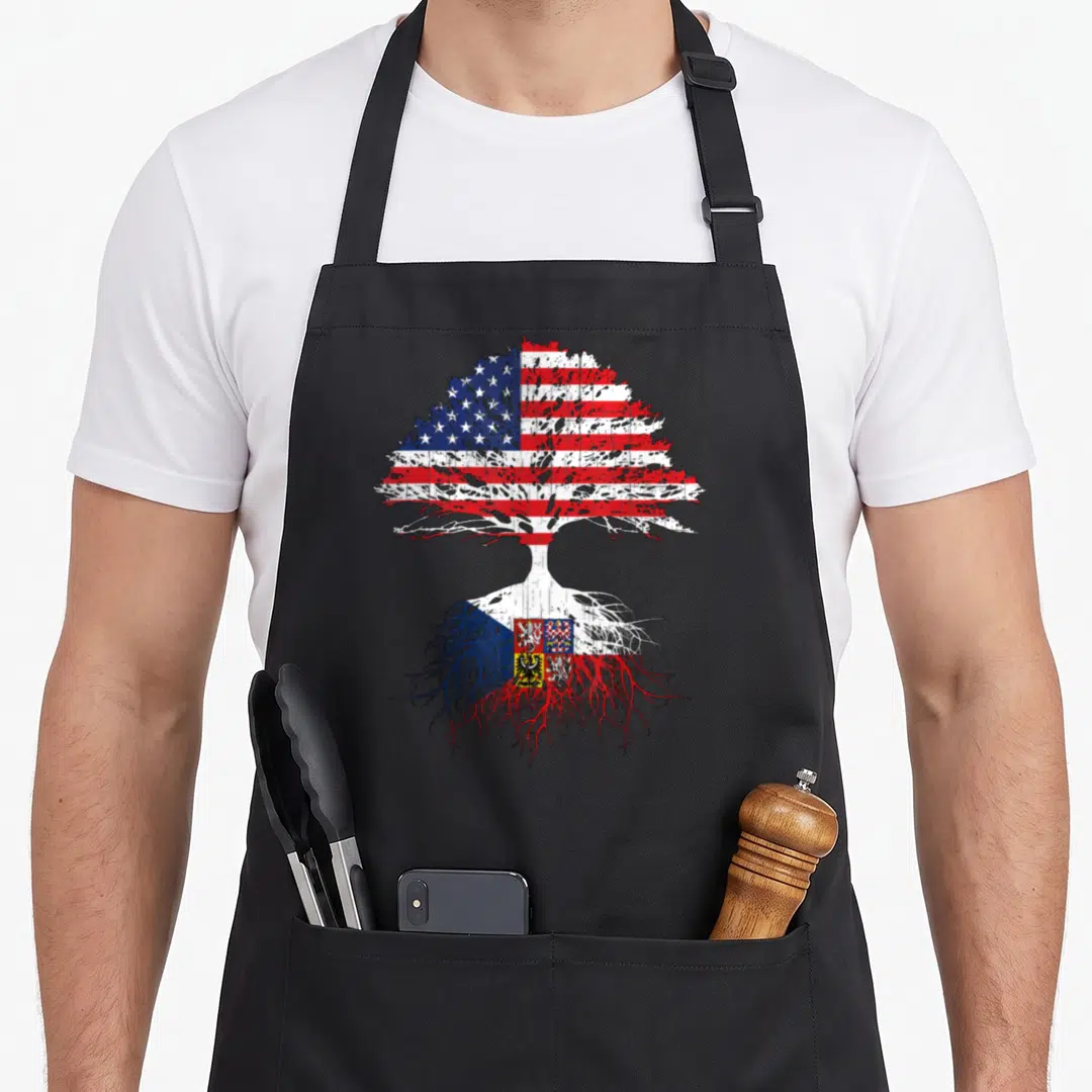 Czech root american flag apron - Distressed tree with US flag canopy and Czech flag roots in red white blue — shown on a black cotton canvas apron against a white background