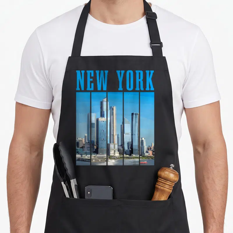 Skyline nyc pride new york apron - Blue NEW YORK text above a five-strip city skyline photo in grey and white tones — shown on a black cotton canvas apron against a white background