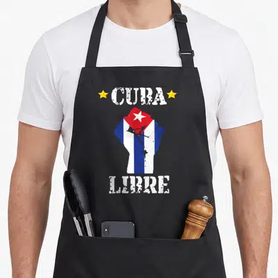 Libre american flag apron - Distressed CUBA LIBRE text and raised fist filled with blue white red and yellow stripes — shown on a black cotton canvas apron against a white background