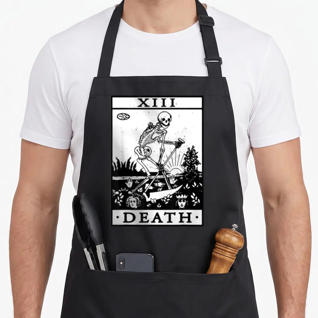 Card tarot apron - Black and white line art of a skeleton with a scythe between text reading XIII and DEATH — shown on a black cotton canvas apron against a white background