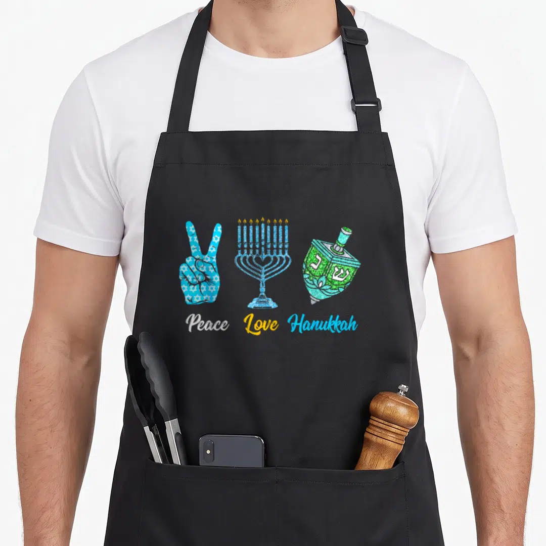 Peace jewish hanukkah apron - Peace sign, menorah, and dreidel in blue, green, yellow, and white with text below — shown on a black cotton canvas apron against a white background