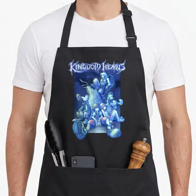 Funny blue crew apron - KINGDOM HEARTS logo above Sora and friends clustered around a stone statue in blue tones — shown on a black cotton canvas apron against a white background