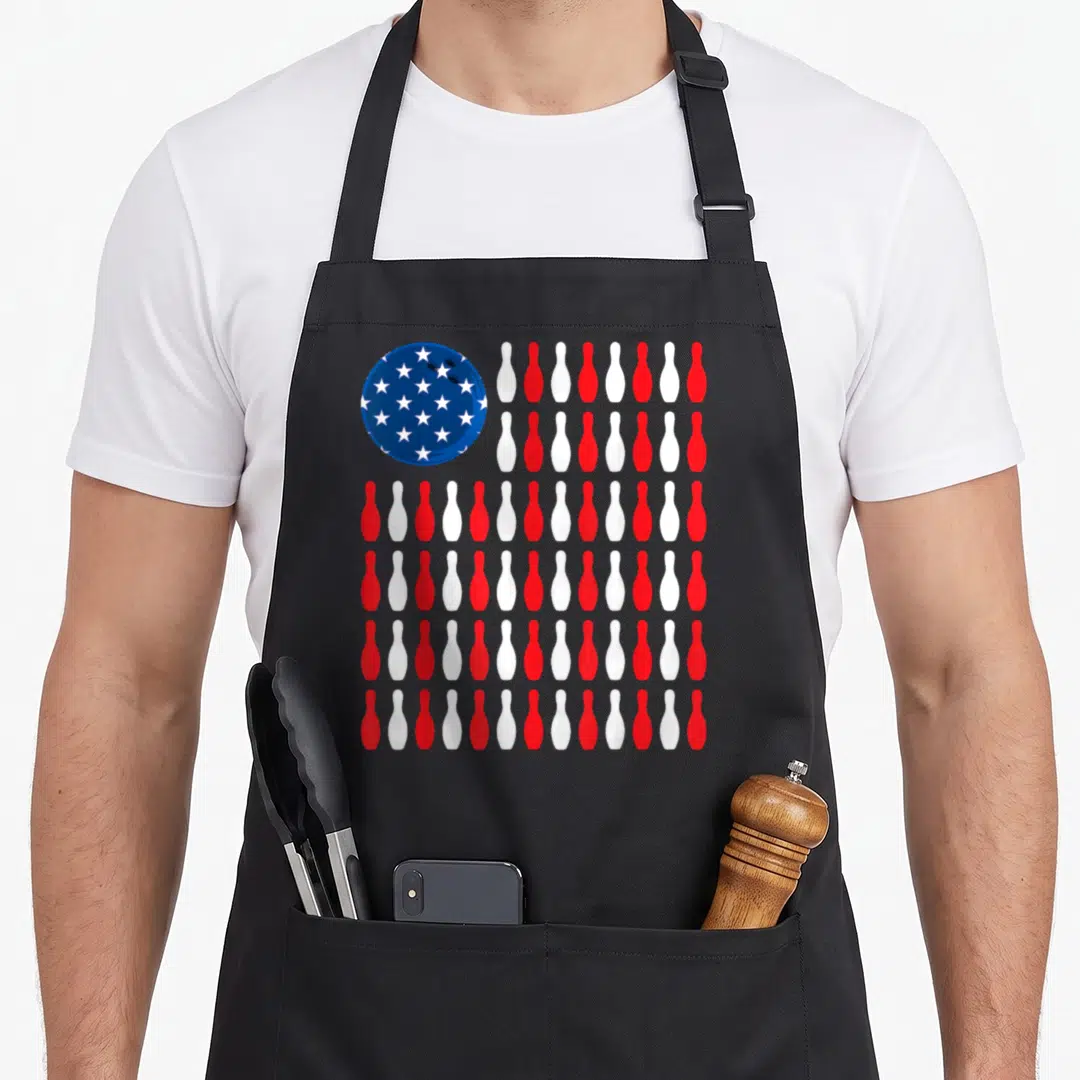 Bowler patriotic aprons - Blue bowling ball with white stars next to red and white pin stripes — shown on a black cotton canvas apron against a white background