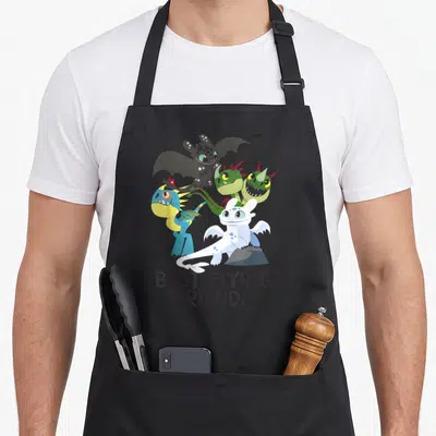 Train friends apron - Five cartoon dragons above BEST FLYING FRIENDS text in black white green blue yellow — shown on a black cotton canvas apron against a white background