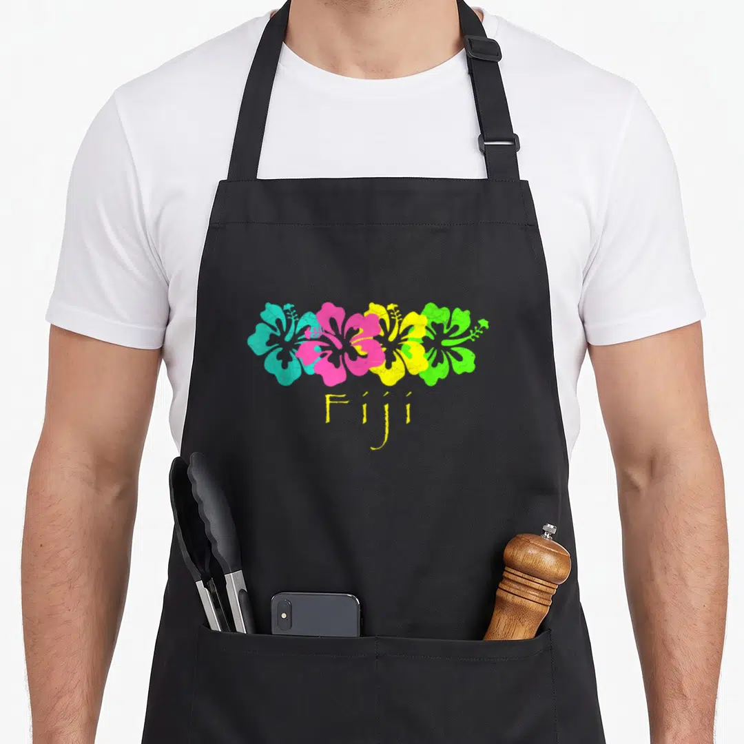 Fiji travel aprons - Four hibiscus flowers in cyan pink yellow and green with Fiji text below — shown on a black cotton canvas apron against a white background