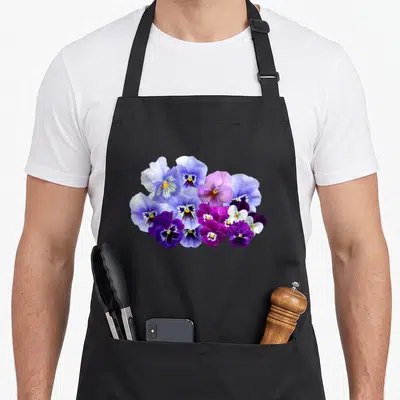 Blue pansy apron - Cluster of purple blue and white pansies in a photo style bunch — shown on a black cotton canvas apron against a white background