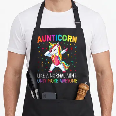 Aunticorn aunt unicorn apron - Dabbing unicorn with rainbow mane and text like a normal aunt only more awesome — shown on a black cotton canvas apron against a white background