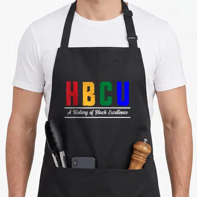 Hbcu college historical aprons - Red orange green blue HBCU letters with white A History of Black Excellence script — shown on a black cotton canvas apron against a white background