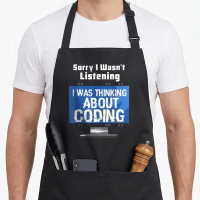 Coding programming apron - Cartoon monitor with glitch text Sorry I Wasn't Listening I Was Thinking About Coding — shown on a black cotton canvas apron against a white background