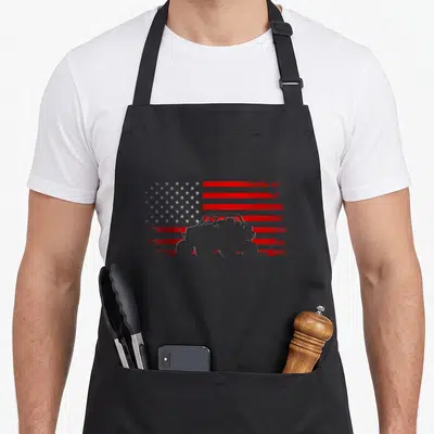 Quad american flag apron - Distressed grey and red USA flag with off-road vehicle silhouette overlay — shown on a black cotton canvas apron against a white background