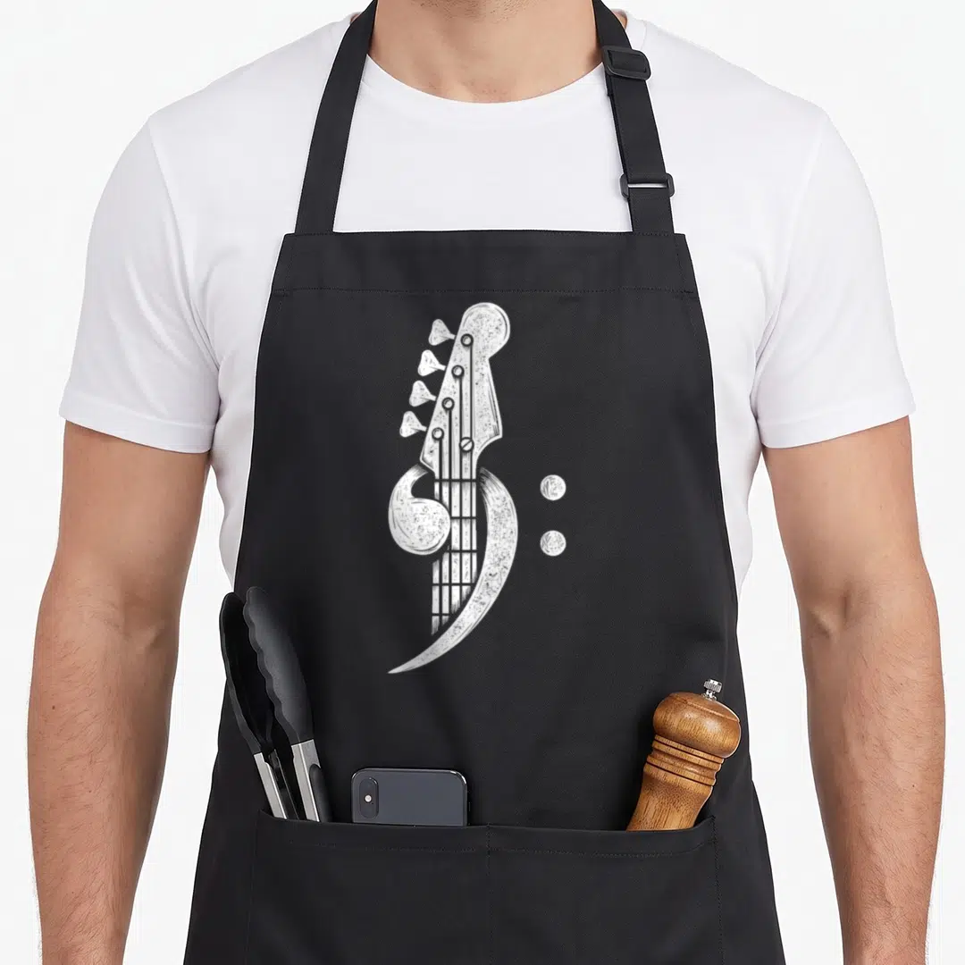 Cleff bass apron - White line art of a bass guitar headstock forming a bass clef symbol next to two dots — shown on a black cotton canvas apron against a white background