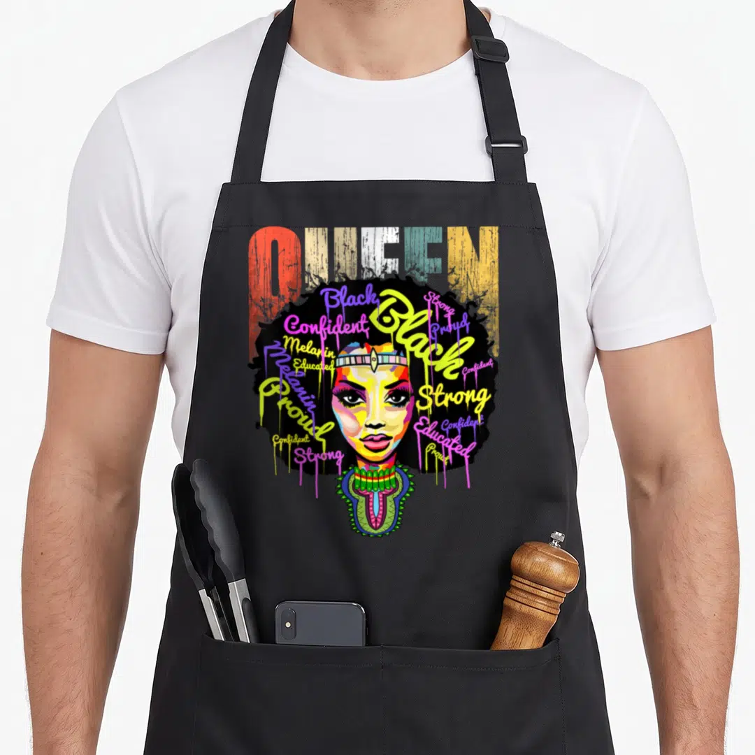 History african apron - Cartoon Black woman face with afro filled with words Strong Proud Confident Educated Melanin — shown on a black cotton canvas apron against a white background