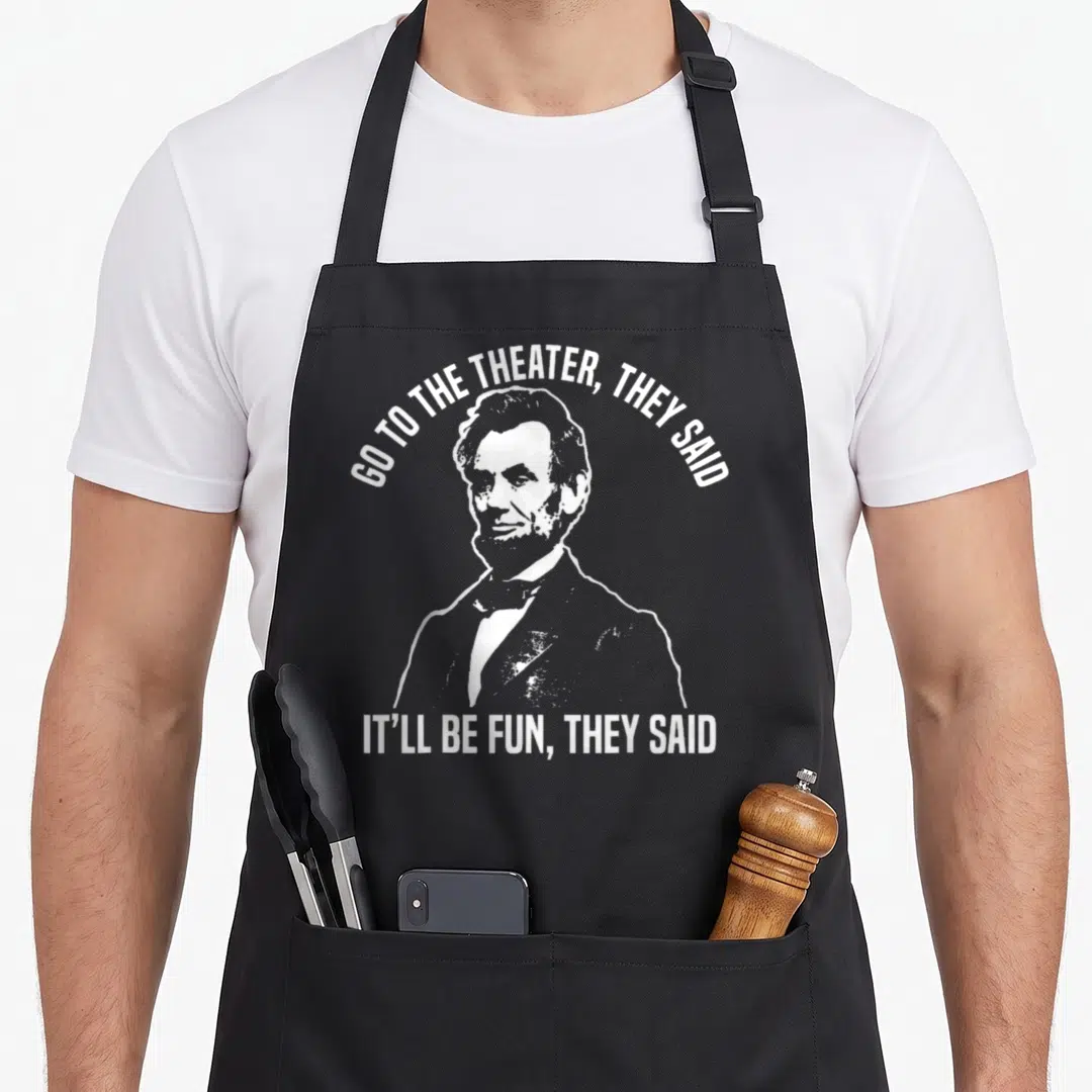 They theater apron - White distressed Abraham Lincoln portrait with arched and straight text quotes — shown on a black cotton canvas apron against a white background