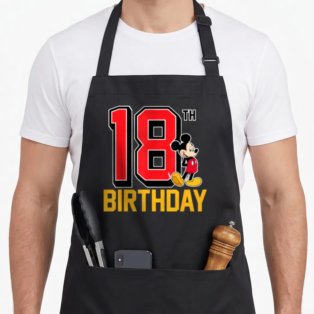 18th birthday apron for kids - Red number 18 with TH and Mickey Mouse standing beside it, BIRTHDAY text in yellow below — shown on a black cotton canvas apron against a white background