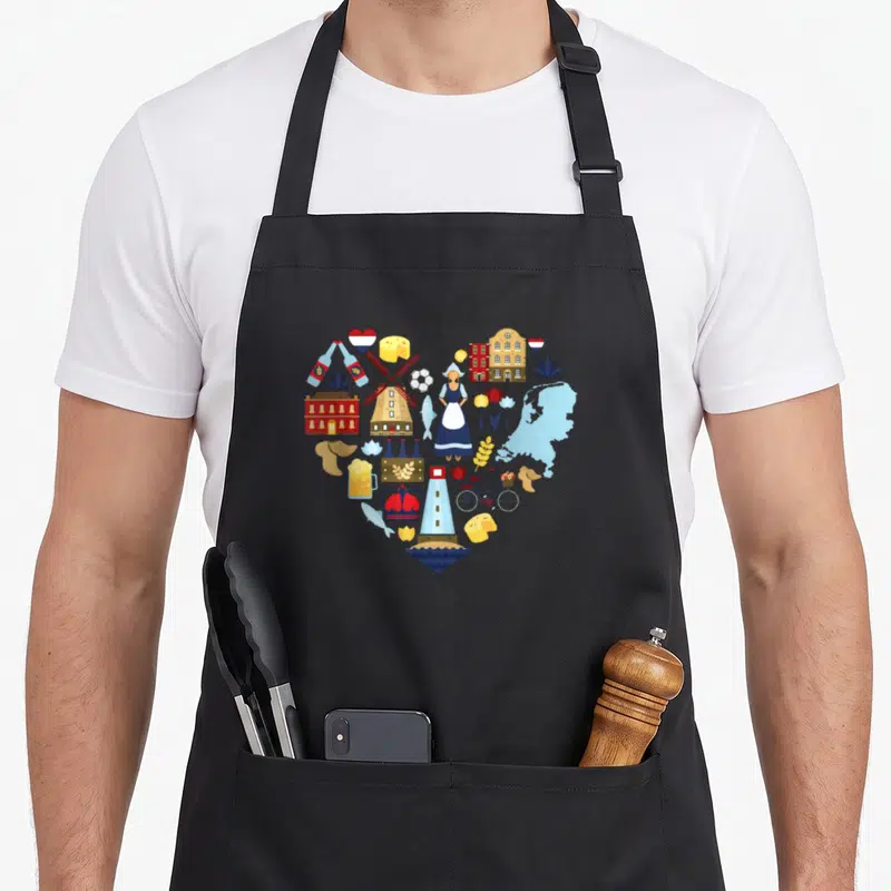 Netherland tulip apron - Heart shape formed by Dutch windmill, tulips, cheese, and bicycle icons in blue red yellow — shown on a black cotton canvas apron against a white background