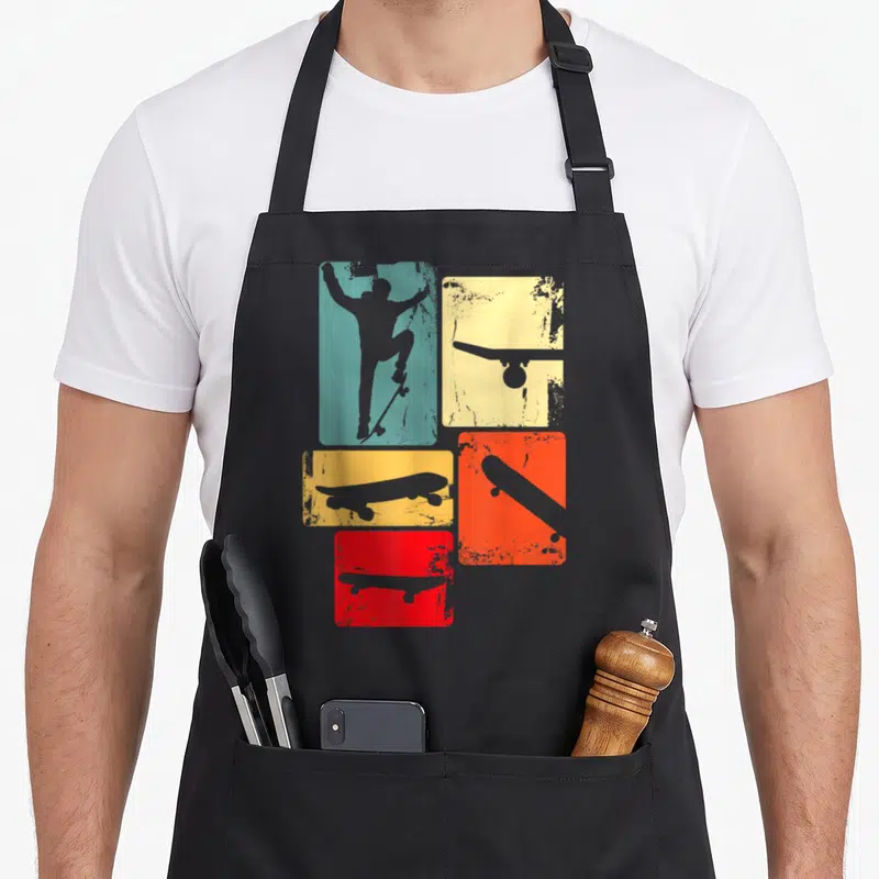 Youth best skater skateboarder accessories stuff apron - Retro teal skater silhouette and grey skateboards inside — shown on a black cotton canvas apron against a white background