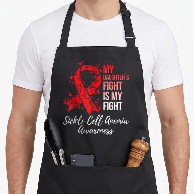 Daughter sickle cell awareness apron - Red ribbon made of hearts with My Daughters Fight Is My Fight text and Sickle — shown on a black cotton canvas apron against a white background