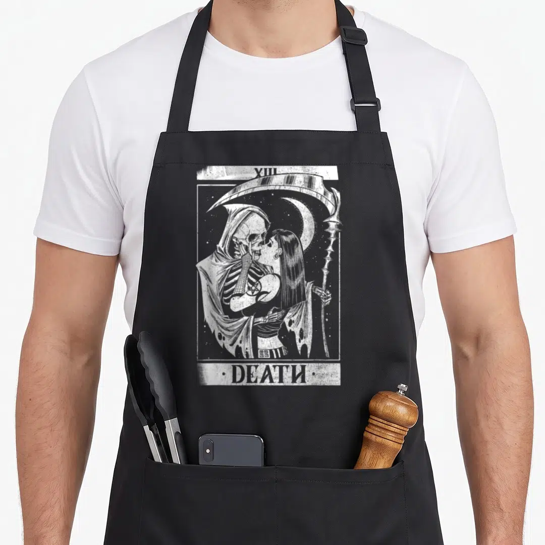 Blackcraft tarot card apron - White line art of skeleton kissing woman with scythe and moon, labeled XIII DEATH — shown on a black cotton canvas apron against a white background