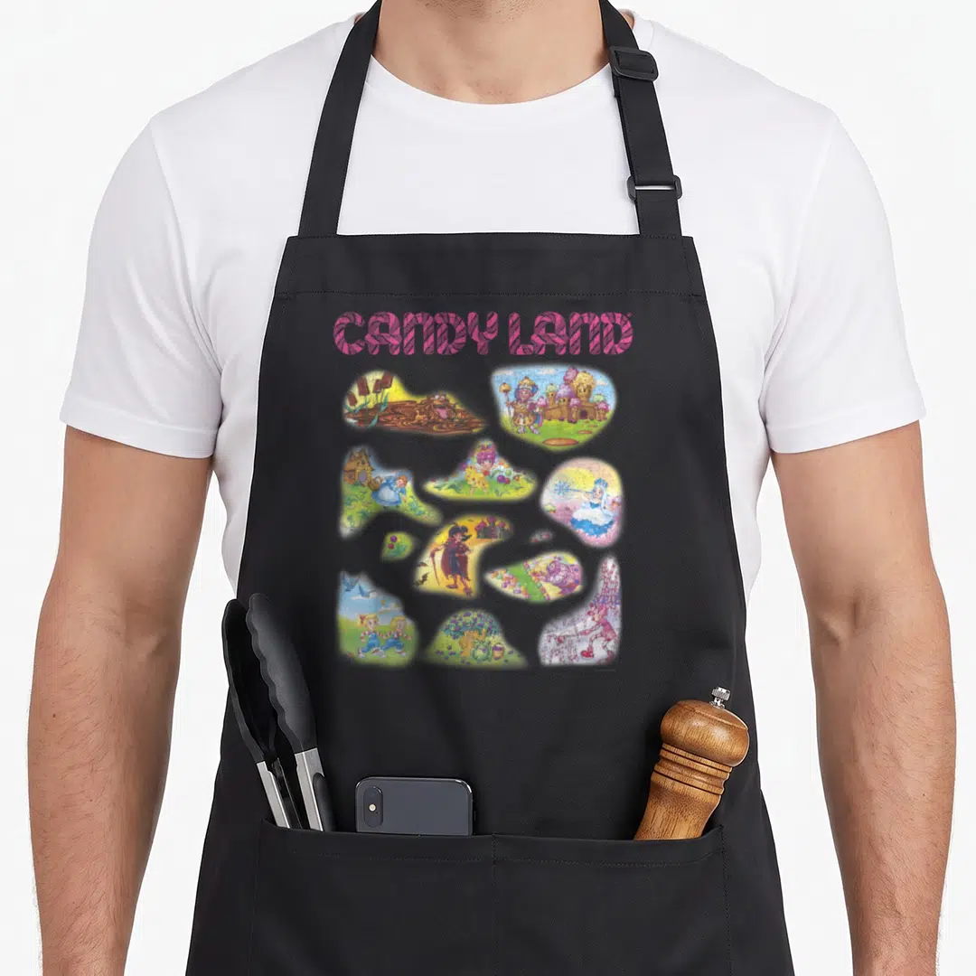 Land candy aprons - CANDY LAND text above scattered cartoon character vignettes in pink blue yellow brown — shown on a black cotton canvas apron against a white background