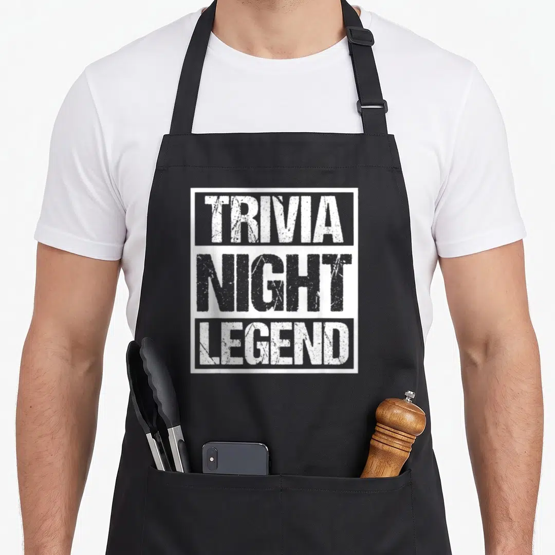 Legend game aprons - White distressed text reading Trivia Night Legend stacked in a box — shown on a black cotton canvas apron against a white background
