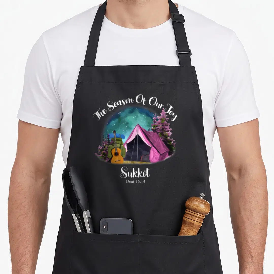 Sukkot dressedforduty apron - Pink tent camping scene with guitar and trees under starry sky with The Season Of Our Joy — shown on a black cotton canvas apron against a white background