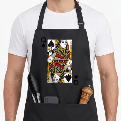 Spade queen apron - Rectangular playing card with Q and spade symbols in red yellow white and black line art — shown on a black cotton canvas apron against a white background