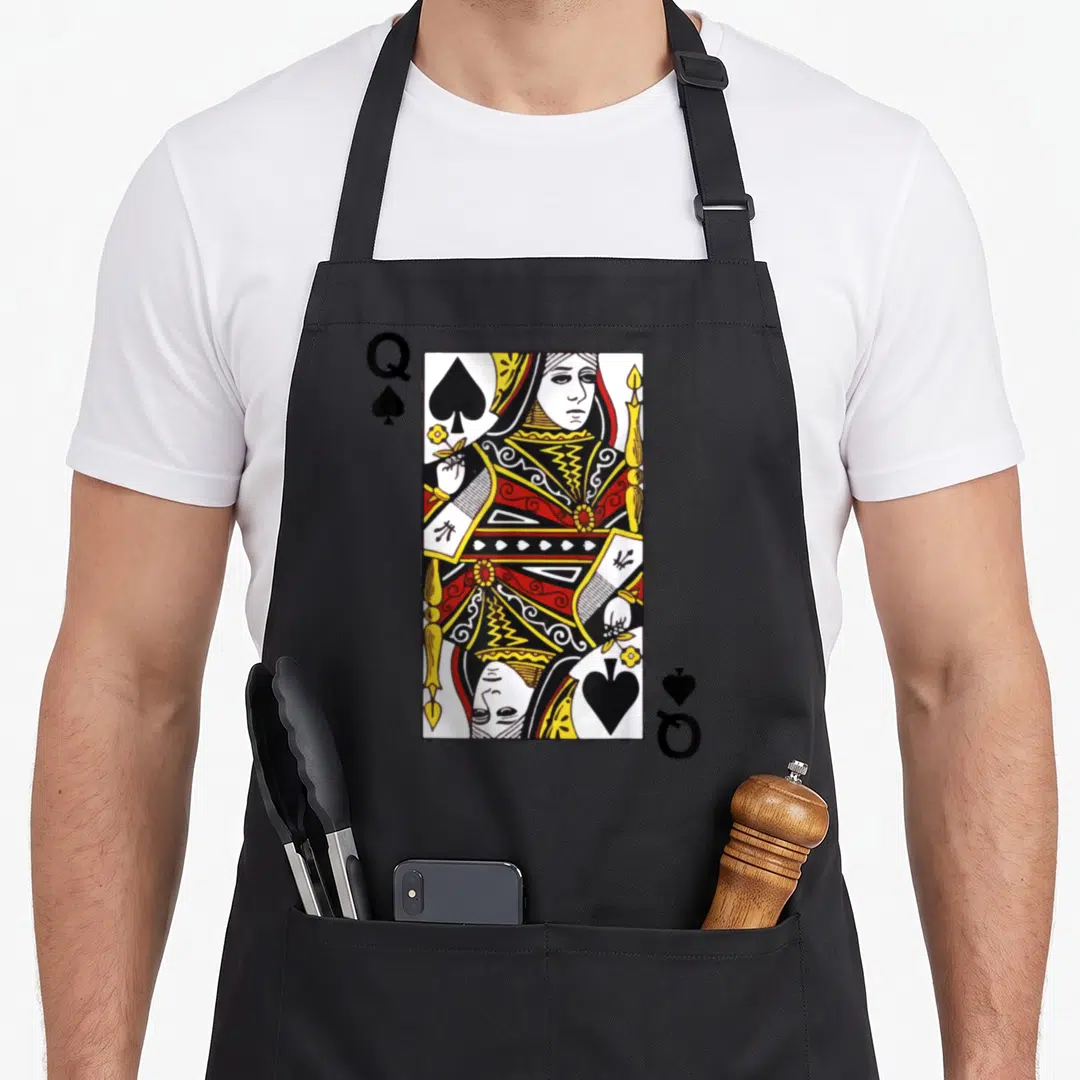 Spade queen apron - Rectangular playing card with Q and spade symbols in red yellow white and black line art — shown on a black cotton canvas apron against a white background