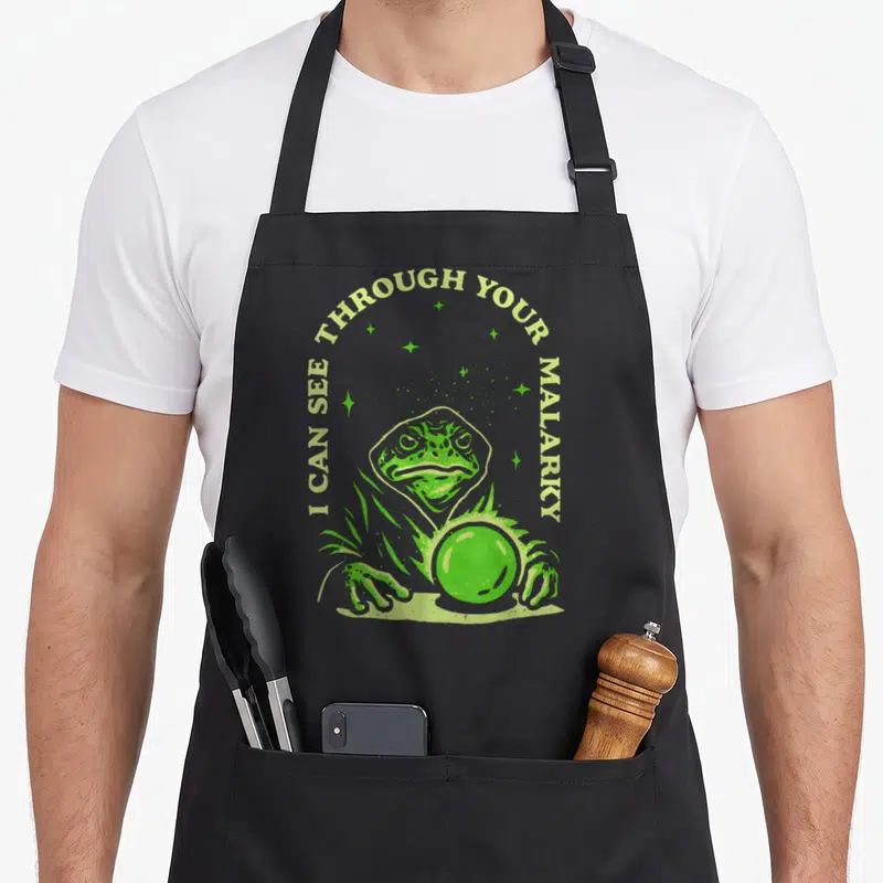 Malarky see through apron - Lime green toad wizard holding crystal ball with arched text and scattered stars — shown on a black cotton canvas apron against a white background