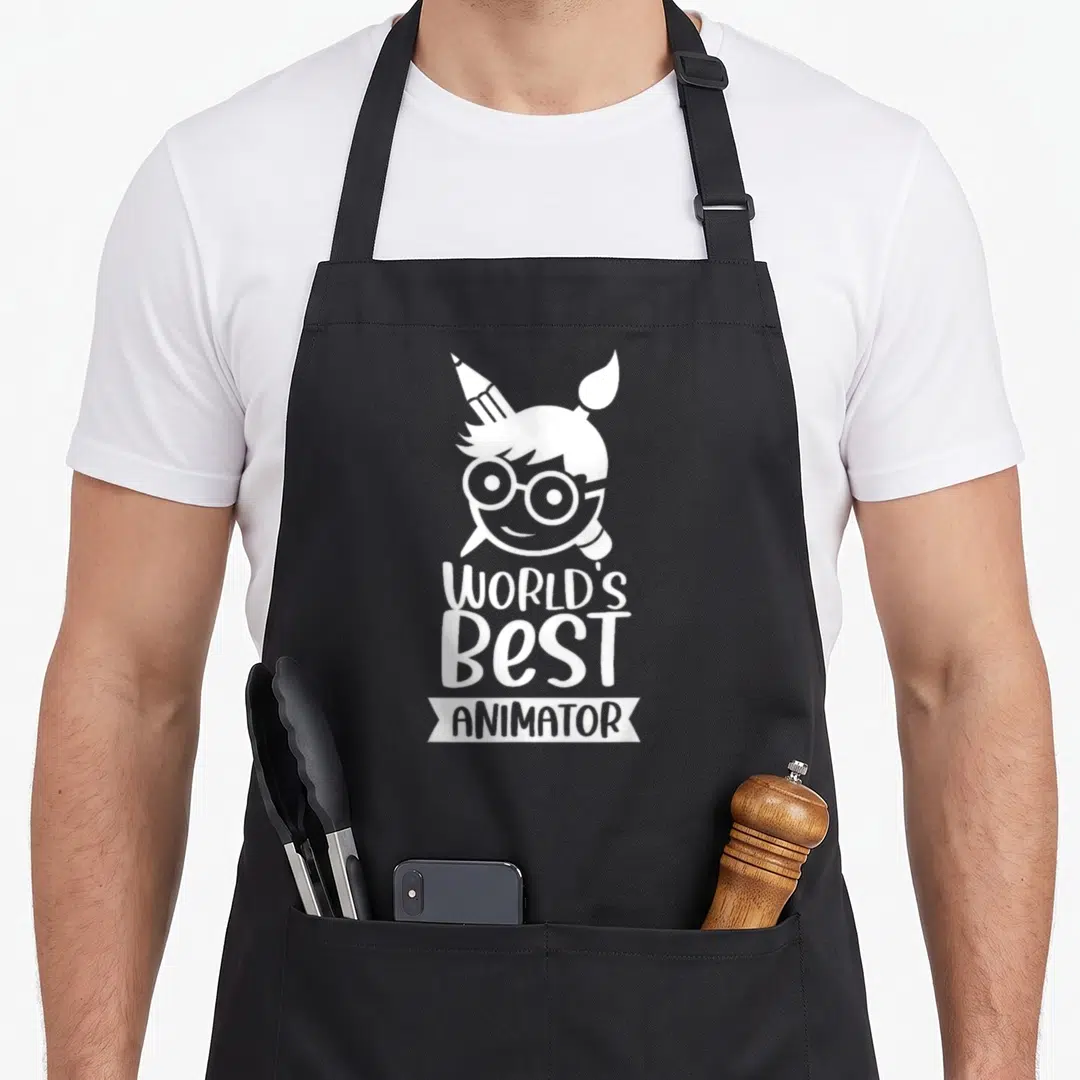 Profession animation apron - White stylized head with glasses and brushes above WORLD'S BEST ANIMATOR text on black — shown on a black cotton canvas apron against a white background