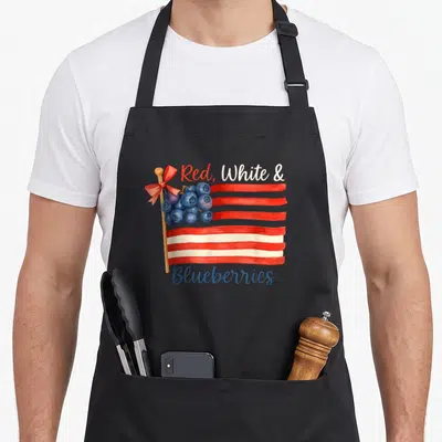 Blueberry american flag apron - Watercolor flag with blueberries replacing stars and red, white, and blueberries text — shown on a black cotton canvas apron against a white background
