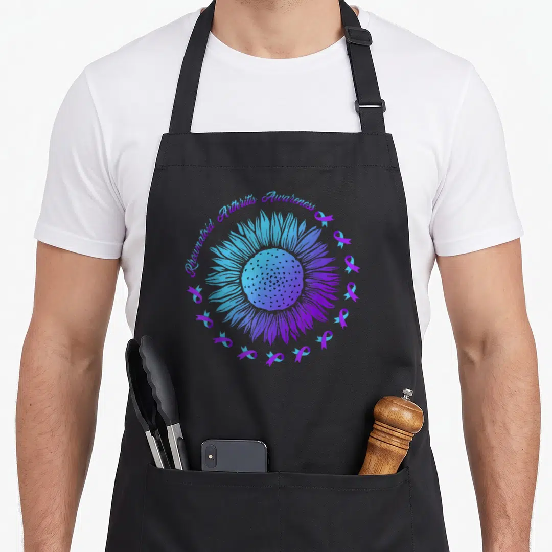 Rheumatoid arthritis awareness ribbon apron - Sunflower and twelve blue purple ribbons with awareness text — shown on a black cotton canvas apron against a white background