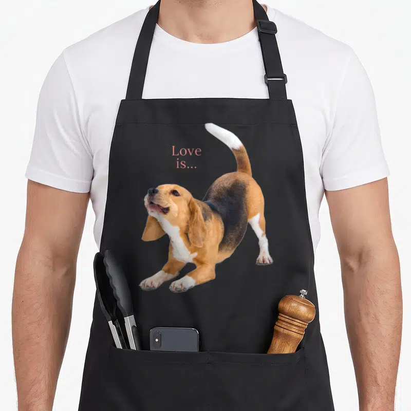 Beagle puppy dog apron - Photo of stretching beagle with pink Love is text above back — shown on a black cotton canvas apron against a white background